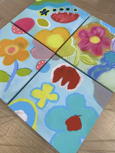 4枚のキャンバスを並べて1枚につなげた完成作品。花や水玉の模様がつながっている