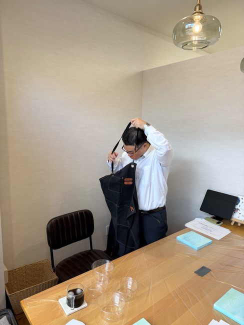 研修の前にエプロンを着ける酒井